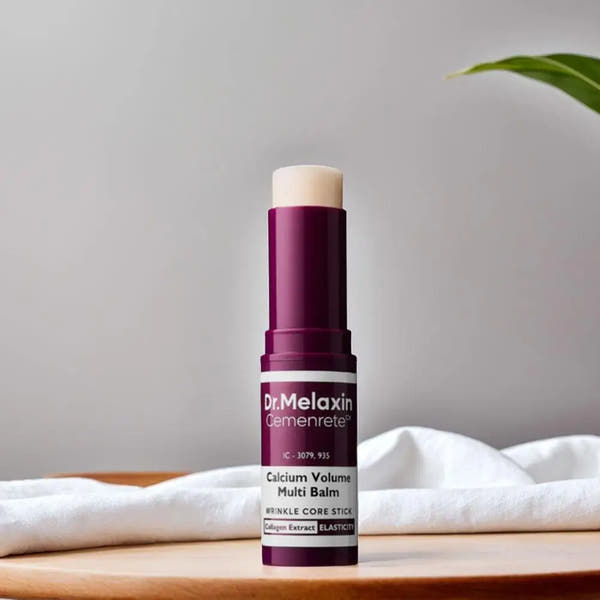 Dr Melaxin calcium multi balm stick in purple and white packaging on wooden surface with white cloth background